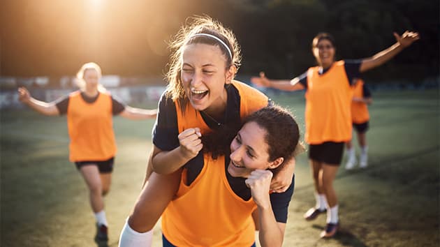 Teenage girls playing football