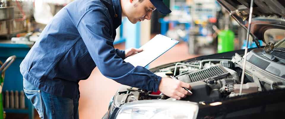 Mechanic inspecting car engine