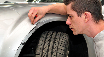 Man inspecting a damaged car